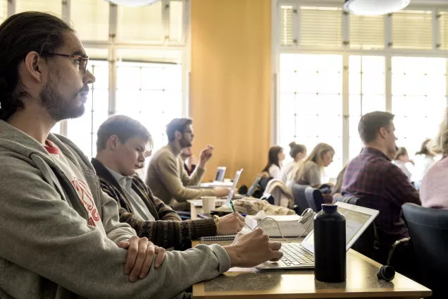Studenter som sitter och lyssnar på en föreläsning. Foto.