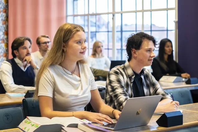 Studenter som sitter i en föreläsningssal. Foto.