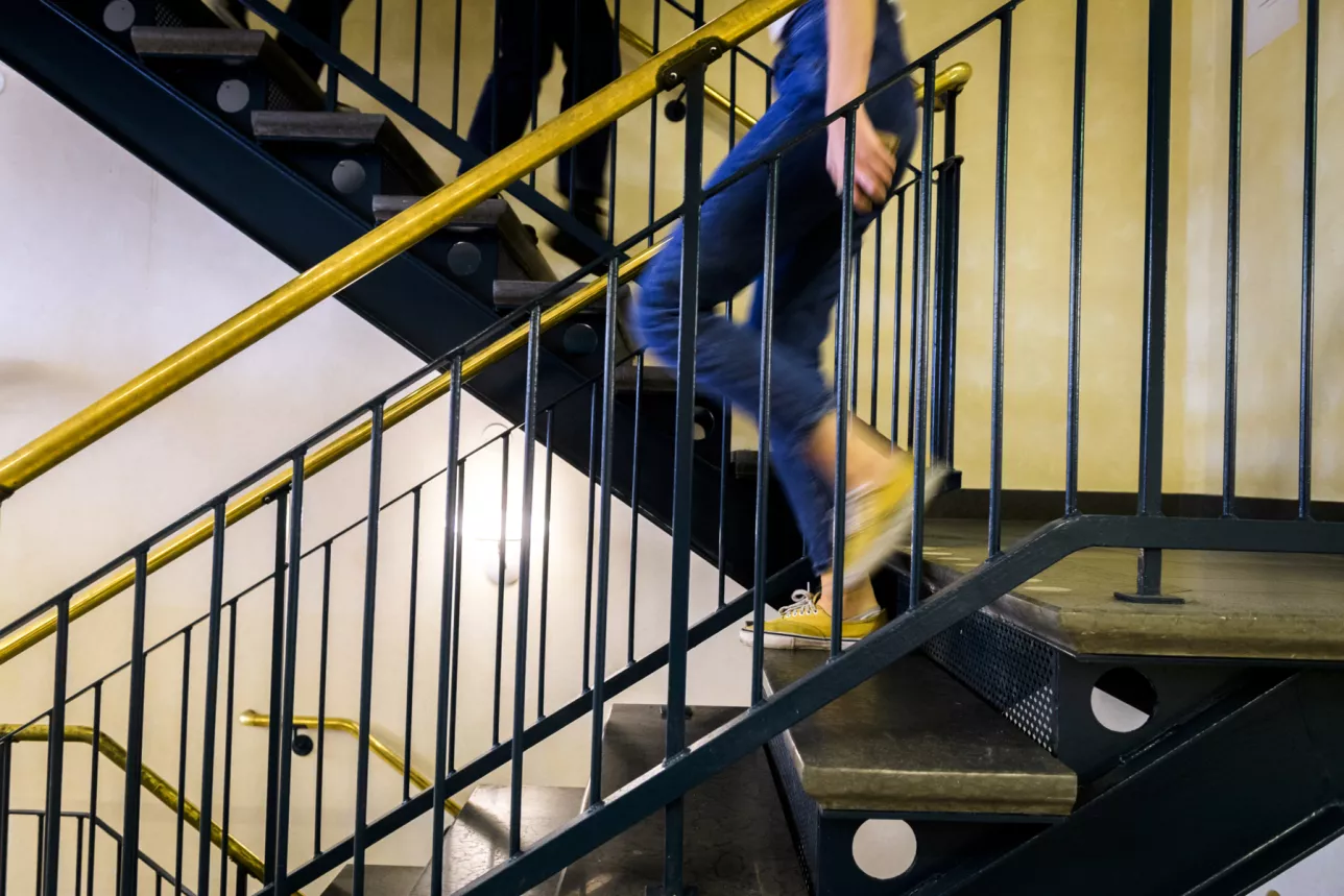 En person går nedför en trappa. Foto.