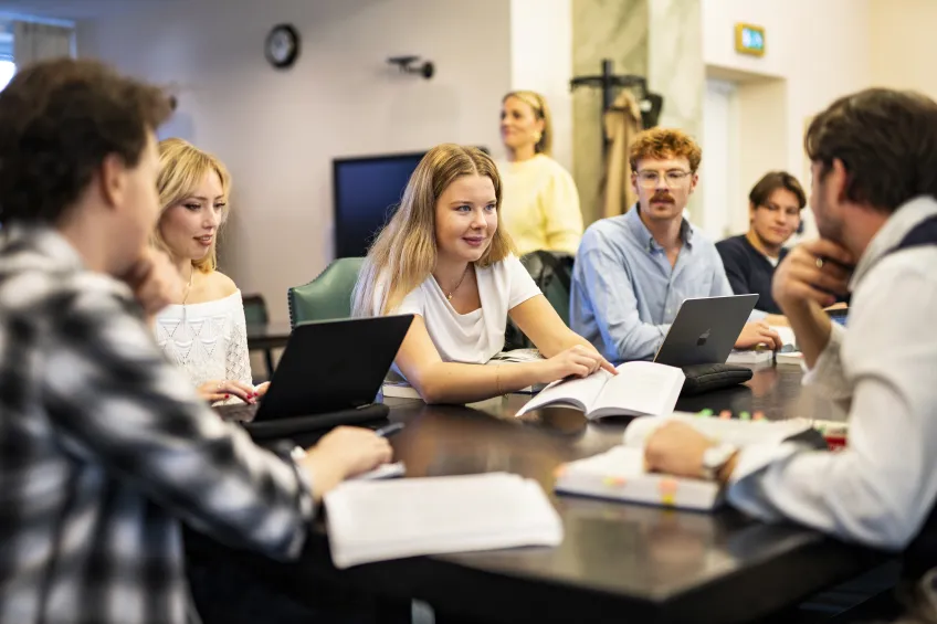 Studenter som sitter runt ett bord och studerar. Foto.